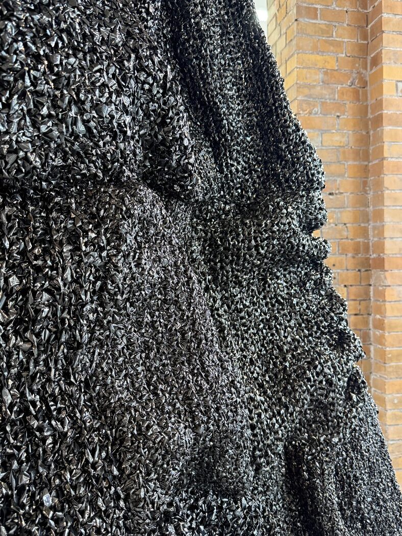 Textural close-up of black sculptural surface by Vanessa Enríquez.